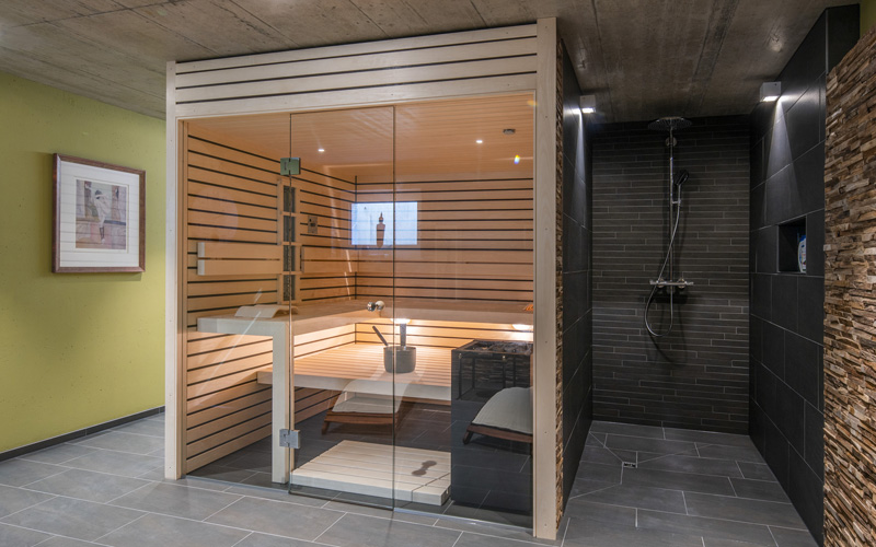 edle Sauna mit Dusche, Biosauna in hellem Holz und Sauna-Glasfront für zuhause, Sauna kaufen nach Mass mit Dusche, Wellnessoase zuhause