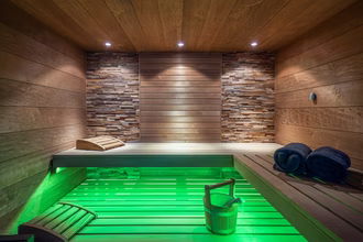 exklusive-sauna-in-dunklem-holz-mit-farblicht-und-glasfront-2